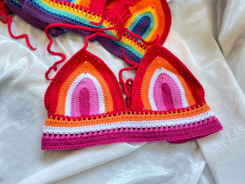 A rainbow crochet top with a halter style neckline. The top is made with a variety of colors, including red, orange, yellow, green, blue, indigo, and violet. The top is crocheted in a simple stitch pattern.