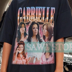 Puede incluir: Camiseta negra de gran tamaño con un estampado gráfico de los personajes de la serie de televisión "Gabrielle" en un estilo retro. El estampado presenta el texto "Gabrielle" en una fuente audaz y colorida.