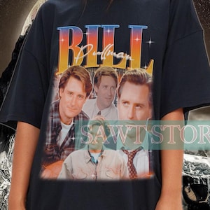 Puede incluir: Camiseta negra de gran tamaño con un estampado gráfico de Bill Pullman de la película "Independence Day". El gráfico incluye el texto "Bill Pullman" y una foto de Bill Pullman con otros actores de la película.