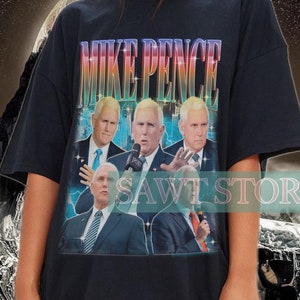 Może przedstawiać: Czarny, oversize'owy T-shirt z nadrukiem graficznym przedstawiającym Mike'a Pence'a i innych mężczyzn w garniturach. Nadruk ma vintage'owy, wyblakły wygląd, a tekst "MIKE PENCE" jest wydrukowany dużymi, pogrubionymi literami.