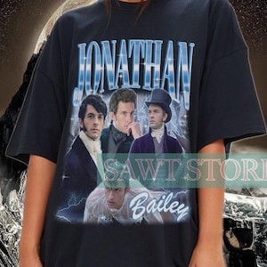May include: Black oversized t-shirt with a vintage-style graphic featuring a band called "Jonathan Bailey". The graphic includes four men in black and white, with the band name in blue and white.