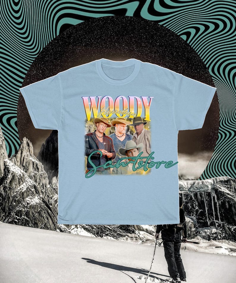 May include: Light blue t-shirt with a vintage-style graphic of four men wearing cowboy hats and the text "Woody's Sanstore".