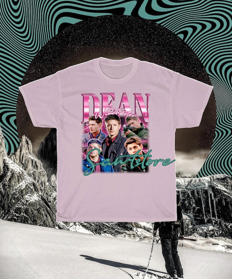 May include: Pink t-shirt with a graphic of Dean Winchester from the TV show Supernatural. The graphic features Dean and other characters from the show in a retro style. The text "Dean Winchester" is in pink and the text "Samstore" is in green.