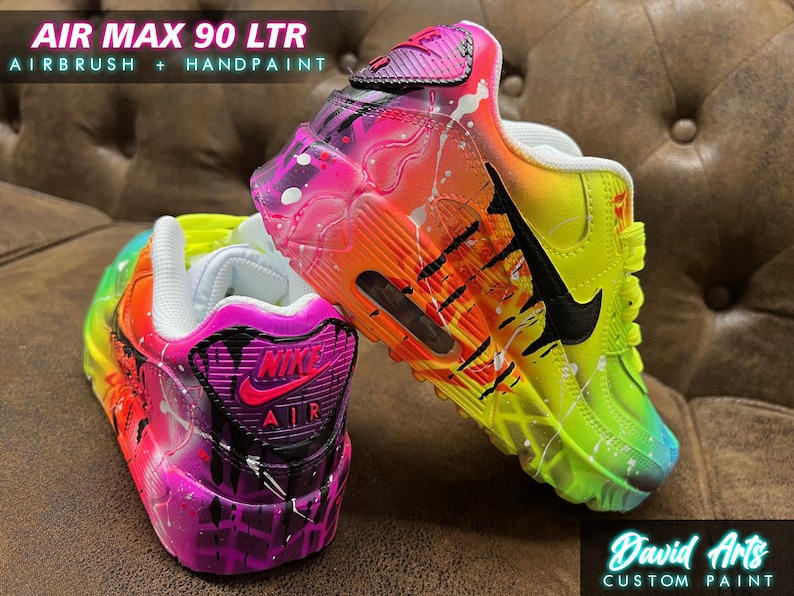 May include: Custom painted Air Max 90 LTR sneakers with a rainbow and black splatter paint design. The shoes are white with a black swoosh and the text "AIR MAX 90 LTR" and "AIRBRUSH + HANDPAINT" on the side.