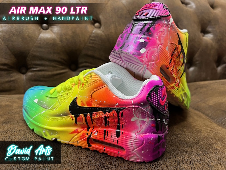 May include: Custom painted Air Max 90 LTR sneakers with a rainbow gradient and black paint drips. The shoes are on a brown leather couch. The text "AIR MAX 90 LTR" and "AIRBRUSH + HANDPAINT" is visible in the image.