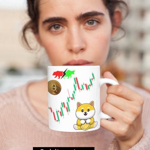 Pode incluir: Caneca de cerâmica branca com uma estampa por sublimação de um cão Shiba Inu segurando uma moeda de ouro, um logotipo Bitcoin, um símbolo de mercado de ações de touro e urso e um gráfico de candlestick. A caneca está sendo segurada por uma pessoa.