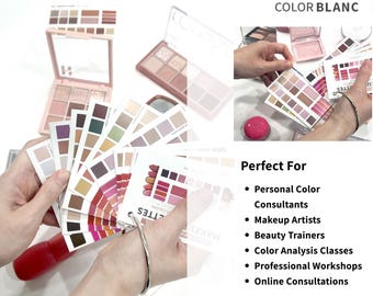 May include: A set of color analysis cards arranged in a fan shape, featuring various makeup shades including pinks, reds, browns, and neutrals. The cards are held together by a metal ring. Additional makeup palettes are visible in the background.