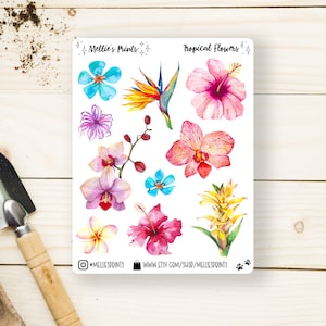 Peut inclure: Une feuille d'autocollants de fleurs tropicales avec une variété de fleurs, notamment des orchidées, des hibiscus et des oiseaux de paradis. Les autocollants sont sur un fond blanc et ont un aspect aquarelle. La feuille comprend également le texte "Millie's Prints" et "Tropical Flowers".