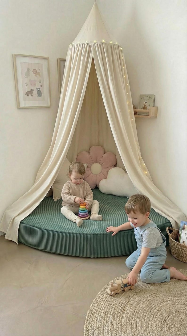 May include: A children's play area with a teal corduroy mat and a draped canopy. Two children play with a wooden toy train and a stacking toy. The scene includes decorative pillows and framed artwork. The mat is approximately 150 cm in diameter.