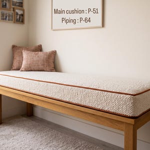 Pode incluir: Um banco de madeira com uma almofada espessa de textura creme e debrum cor de ferrugem. Duas almofadas retangulares de tecido cor de ferrugem est&atilde;o sobre o banco. Uma placa acima diz Main cushion : P-51 Piping : P-64.