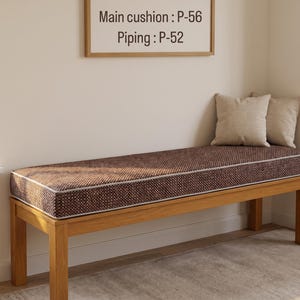 Pode incluir: Um banco de madeira com uma almofada retangular de textura castanha e debrum claro. A almofada est&aacute; etiquetada como Main cushion: P-56 e Piping: P-52. Duas almofadas decorativas quadradas bege est&atilde;o colocadas no lado direito do assento.