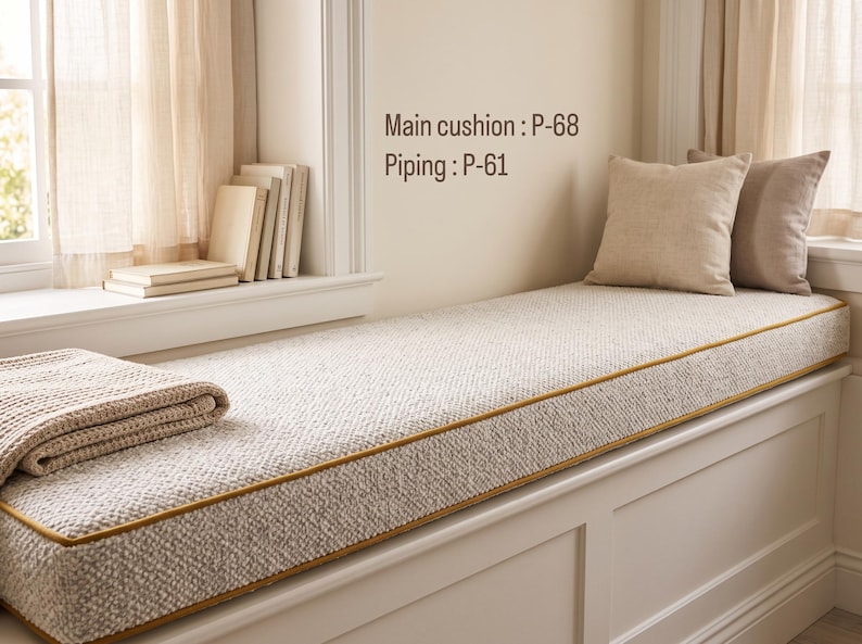 Pode incluir: Uma almofada retangular longa para banco de janela com tecido creme texturizado e debrum amarelo mostarda. O texto Main cushion : P-68 e Piping : P-61 &eacute; vis&iacute;vel. Duas almofadas quadradas em bege s&oacute;lido est&atilde;o posicionadas &agrave; direita.