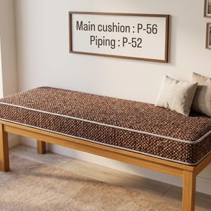 Pode incluir: Um banco de madeira com uma almofada castanha comprida e texturada com debrum claro. A almofada tem a etiqueta Main cushion: P-56 e Piping: P-52. Duas pequenas almofadas retangulares bege claro repousam no lado direito do assento.