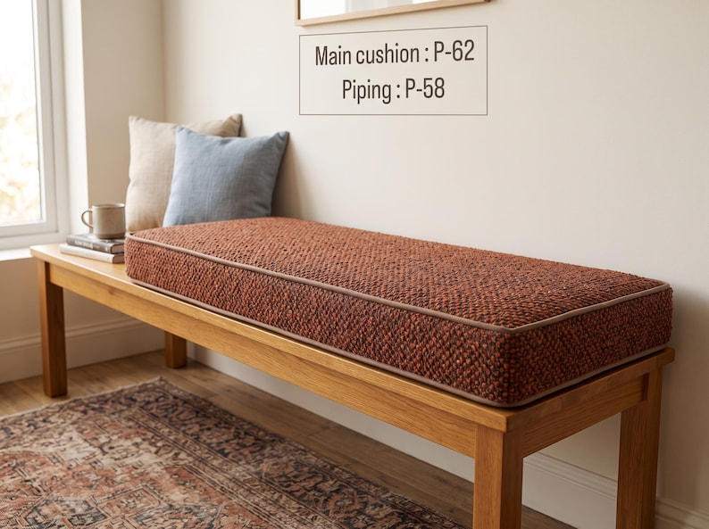 Pode incluir: Uma almofada retangular para banco em tecido entrela&ccedil;ado de cor laranja queimado com textura e debrum a condizer. A almofada apresenta uma etiqueta com o texto Main cushion : P-62 e Piping : P-58. A almofada est&aacute; sobre um banco de madeira.
