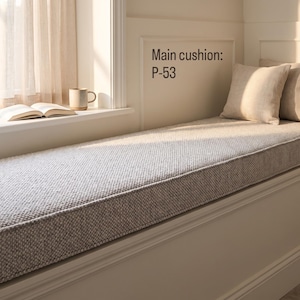 Pode incluir: Uma almofada retangular longa para assento de janela com capa de tecido texturizado cinza-claro. Duas almofadas quadradas de cor bege s&oacute;lido est&atilde;o posicionadas &agrave; direita. O texto "Main cushion: P-53" est&aacute; impresso na parede acima.