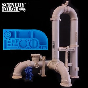 May include: A silicone mold for creating a detailed model of a pipe system. The mold is blue and features a variety of pipe shapes, valves, and other details. The mold is shown next to a model of the pipe system, which is made of gray plastic.