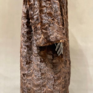 May include: A brown fur coat with a long, straight cut. The coat is made of a soft, luxurious fur and has a classic, elegant style.