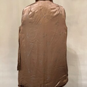 May include: A brown fur coat with a fur collar. The coat is lined with a brown satin fabric with a floral pattern.