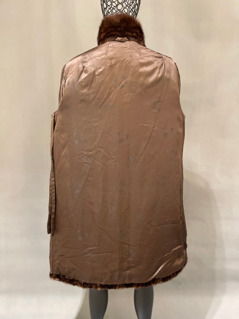 May include: A brown fur coat with a fur collar. The coat is lined with a brown satin fabric with a floral pattern.