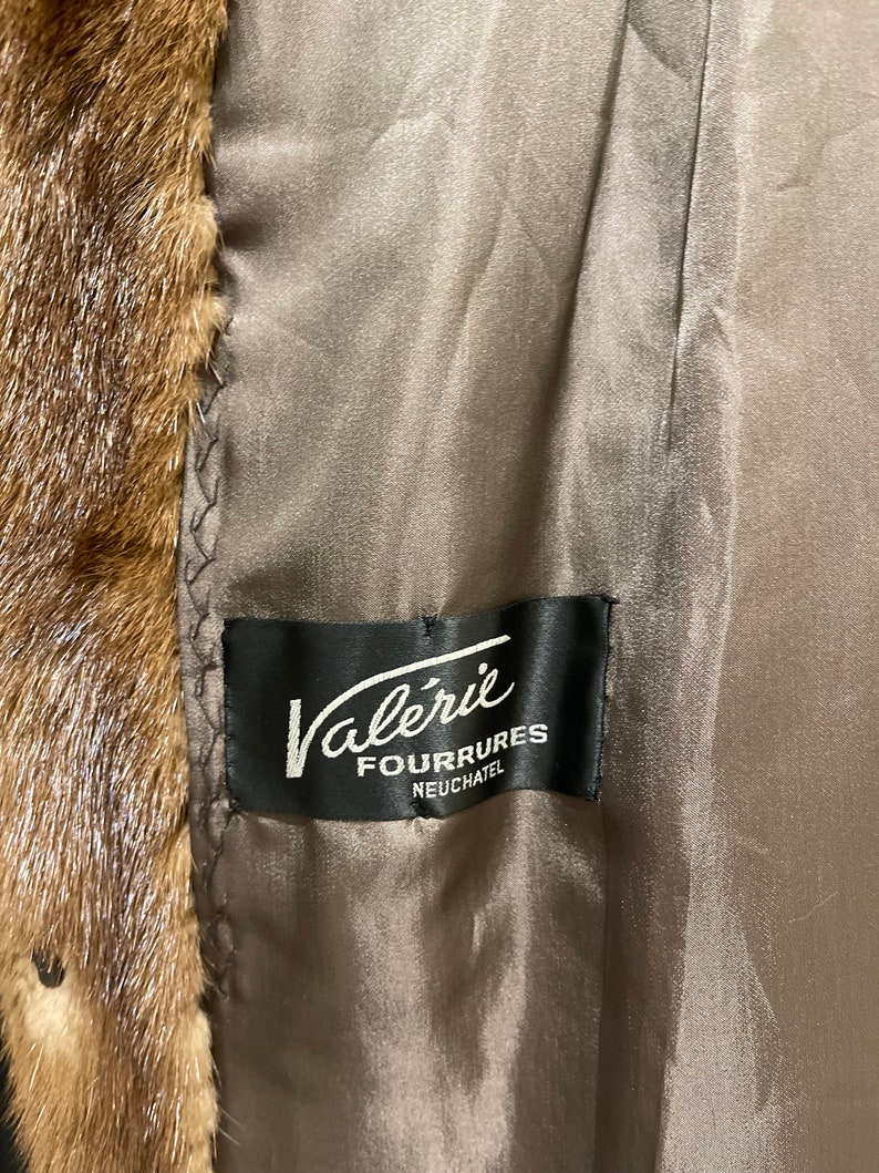 May include: A brown fur coat with a black label that reads "Val&eacute;rie Fourrures Neuch&acirc;tel".