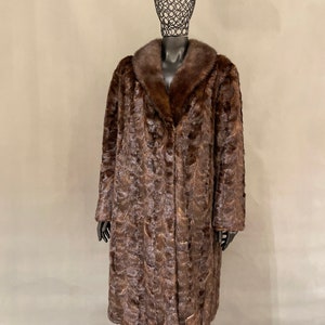 May include: A long brown fur coat with a large fur collar. The coat is made of a soft, luxurious fur and has a classic, elegant style.