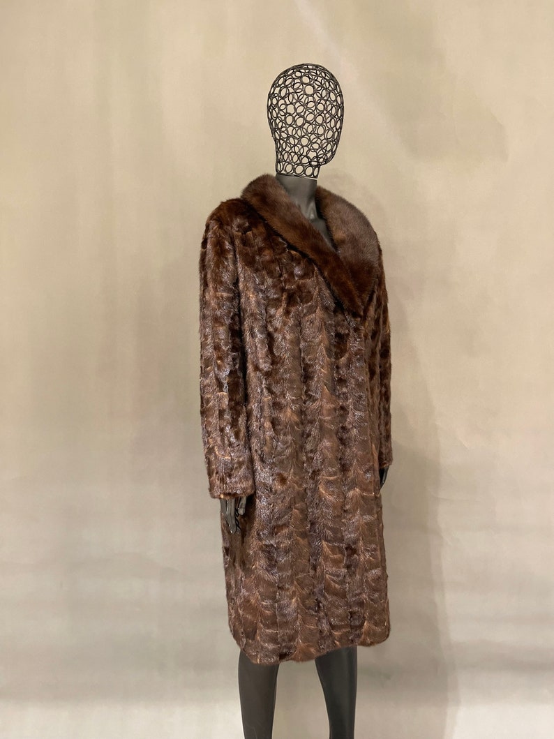 May include: A long brown fur coat with a large collar. The coat is made of a soft, luxurious fur and has a classic, elegant style.