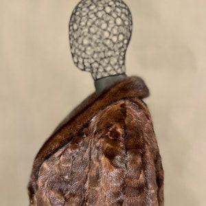 May include: A brown fur coat with a large collar. The coat is made of a soft, luxurious fur and has a classic, elegant style.