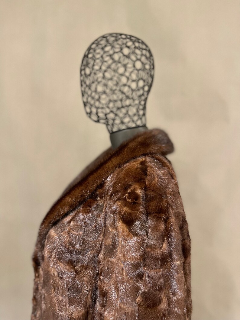 May include: A brown fur coat with a large collar. The coat is made of a soft, luxurious fur and has a classic, elegant style.