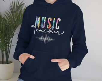 May include: A navy blue hoodie with a white graphic that says "MUSIC teacher" in rainbow colors with a sound wave graphic underneath.