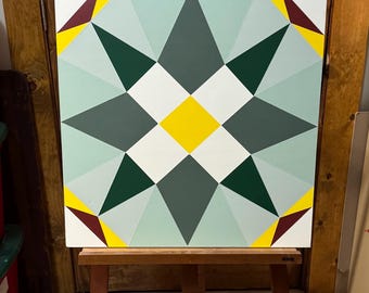 May include: A square barn quilt with a geometric design featuring a white center with a yellow diamond, surrounded by green and gray triangles, and a burgundy and yellow border.