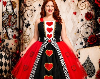 May include: A sleeveless dress featuring a black bodice with a white center panel adorned with three red hearts. The skirt consists of red and black tulle layers with red heart appliqués and a central black and white checkered vertical sash.