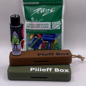 Puede incluir: Un surtido de accesorios para fumar, que incluye un encendedor con un diseño de hoja de dibujos animados, una bolsa verde de filtros y dos cajas marrones y verdes con la etiqueta "Pieff Box". La bolsa dice "Purize" y "Activated Carbon Filter".