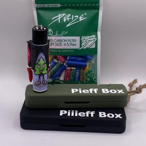 Puede incluir: Una bolsa verde y blanca con el texto "PURIZE" y "RED CARBON FILTER LIM SIZE-5,9mm MADE IN GERMANY". La bolsa contiene una variedad de filtros de cigarrillos de colores. Un encendedor verde, negro y rojo con un personaje de dibujos animados está al lado de la bolsa. El encendedor está sentado encima de una caja verde y negra con el texto "Pieff Box" y "Piiieff Box" en ella.