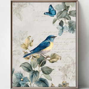 Puede incluir: Una lámina de arte enmarcada que muestra un pájaro azul posado en una rama con hojas verdes y una mariposa azul encima. El fondo consiste en una superficie de color crema claro con texto en cursiva tenue detrás de los elementos botánicos.