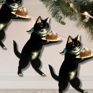Può includere: Illustrazione di gatti neri che trasportano budini di Natale su piccoli piatti di legno. I gatti indossano sciarpe verdi, sullo sfondo di un albero di Natale e luci.