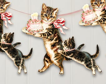 May include: A decorative banner featuring a repeating illustration of brown tabby kittens. Some kittens stand upright wearing pink ribbons and holding plates with pink frosted cakes topped with lit candles, while others are shown playing.