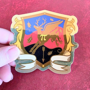 Puede incluir: Adhesivo con diseño de escudo de armas con un ciervo alado y el símbolo pi. El escudo tiene un borde dorado y una pancarta en la parte inferior. Los colores de fondo incluyen azul, rojo y negro.