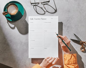 May include: A white daily teacher planner with sections for "Focus", "To Grade", "To Create", "To Plan", "To Do", and "Notes". A person is writing on the planner with a pencil.