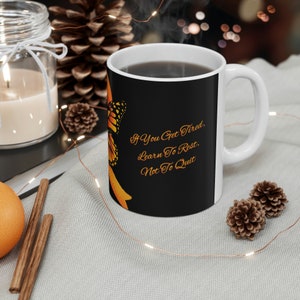 May include: A black and white coffee mug with an orange butterfly design and the text "If you get tired, learn to rest, not to quit".