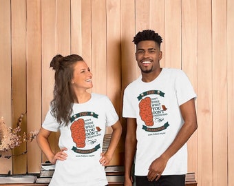May include: Two people wearing white t-shirts with a graphic of a brain with the text "FND Don't Judge What You Don't Understand" and "Awareness" with the website address www.fnda.org.au.