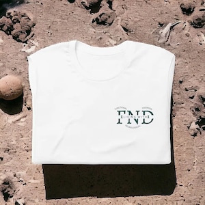 Könnte beinhalten: Weißes T-Shirt mit einem schwarzen und grünen Grafikdesign, auf dem "Functional Neurological Disorder Living With FND" steht.