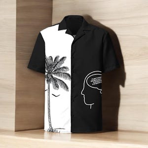 Könnte beinhalten: Kurzärmeliges Button-up-Hemd mit geteiltem Design. Eine Seite zeigt eine schwarz-weiße Palmenillustration, während die andere Seite schwarz ist mit einer weißen Umrisszeichnung eines Kopfes und dem Text "FUNCTIONAL NEUROLOGIC DISORDER AWARENESS".