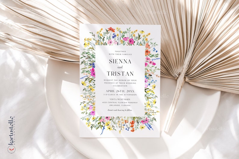May include: A wedding invitation with a floral border featuring colorful wildflowers. The invitation includes the names "Sienna and Tristan" and event details. The design is set against a white background with a dried palm leaf.