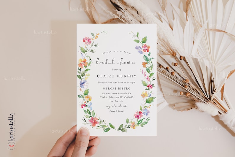 Puede incluir: Una invitaci&oacute;n a una despedida de soltera floral con una corona de acuarela de flores rosas, amarillas, azules y naranjas. El texto de la invitaci&oacute;n dice: "Por favor, &uacute;nase a nosotros para una despedida de soltera en honor a Claire Murphy S&aacute;bado, 27 de junio de 20XX a las 3:00 pm Mercat Bistro 121 Main Street, Louisville, KY RSVP a Rebecca al 123.456.7890 antes del 15 de mayo registrado en Crate & Barrel"