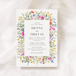 May include: Wedding invitation featuring a floral border with colorful wildflowers in shades of pink, yellow, blue, and orange. The invitation has a rectangular text box with the names "Sienna and Tristan" and event details.