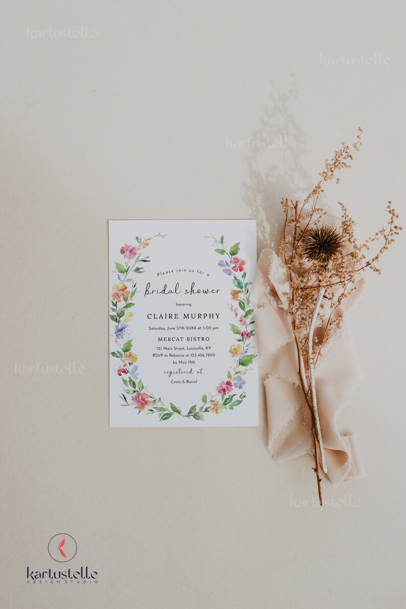 Puede incluir: Una invitaci&oacute;n de ducha nupcial floral con una corona de acuarela de flores rosas, amarillas y azules. La invitaci&oacute;n es para Claire Murphy e incluye la fecha, la hora, la ubicaci&oacute;n y la informaci&oacute;n de RSVP. El texto dice "Por favor, &uacute;nase a nosotros para una bridal shower en honor a Claire Murphy S&aacute;bado, 27 de junio de 20XX a las 3:00 pm Mercat Bistro 121 Main Street, Louisville, KY RSVP a Rebecca al 123.456.7890 antes del 15 de mayo registrado en Crate & Barrel"