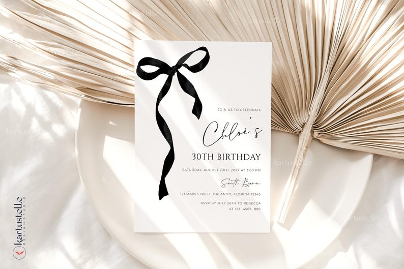 K&ouml;nnte beinhalten: Eine wei&szlig;e Einladungskarte mit einer schwarzen Schleifenillustration und Text. Die Einladung lautet "Chloe's 30. Geburtstag" mit Veranstaltungsdetails. Die Karte liegt vor einem neutralen Hintergrund mit einem getrockneten Palmblatt.