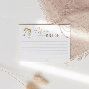 May include: A white card with gold text that reads "Advice for the Bride". The card has a watercolor illustration of two champagne flutes and a pearl necklace. There is a line at the bottom for the person to sign their name.