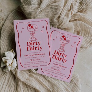 Puede incluir: Dos invitaciones rosas de cumplea&ntilde;os "Dirty Thirty" con una ilustraci&oacute;n de c&oacute;ctel rojo. Las invitaciones incluyen detalles del evento como la fecha, hora y lugar. El dise&ntilde;o tiene un borde rojo.