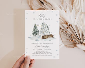 Op de afbeelding: Een uitnodiging voor een babyshower met een winterthema. De kaart toont een aquarel illustratie van met sneeuw bedekte dennenbomen, een boomstam en de tekst "Baby, It's Cold Outside". De uitnodiging bevat details voor Chloe Martiny's babyshower.